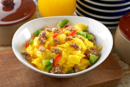 Scrambled eggs with minced meat and vegetables in a white bowlの写真素材