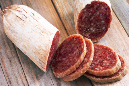 slices of salami on a wooden background. selective focusの写真素材