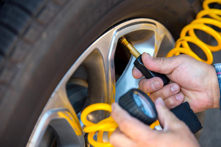 mechanic changing a car wheel, closeup of hands with wrenchの写真素材