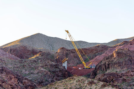 Crane on a construction site in desert landscape at sunset, Nevada