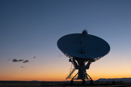 The silhouette of a radio telescope against the backdrop of the setting sunの写真素材
