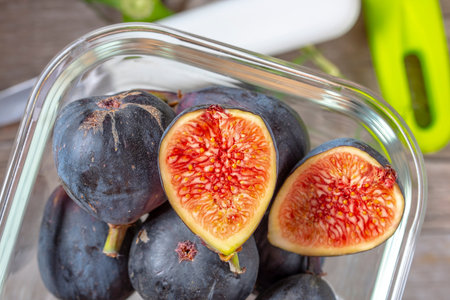 Ripe figs in a glass bowl on a wooden table.の写真素材