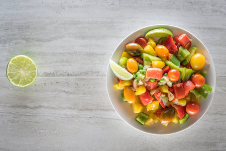 Top view of colorful vegetable salad in white bowl on concrete background.の写真素材