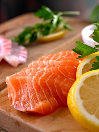 salmon fillet with lemon and parsley on wooden cutting boardの写真素材