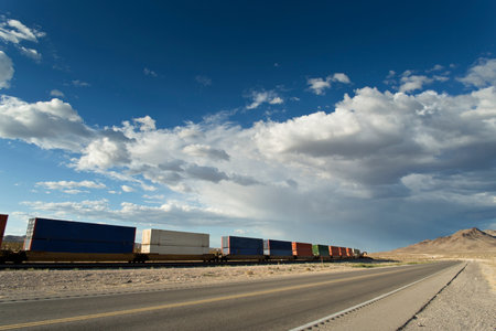 Freight cars on the road in the desert with blue sky and cloudsの写真素材