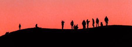Silhouette of a group of people on a hill at sunset