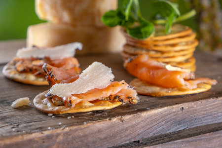 snacks with smoked salmon, cheese and herbs on a wooden table