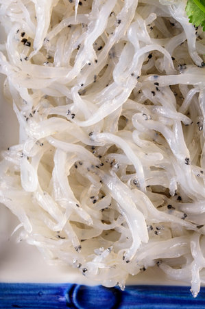 Japanese rice noodles with sesame seeds on a blue plate, close upの写真素材