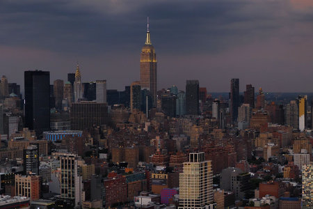 New York City Manhattan downtown skyline with Empire State Building at sunset.