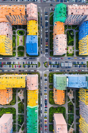 Aerial view of a parking lot with cars and buildings in the city