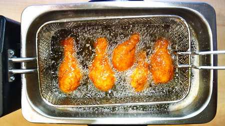 Fried chicken wings in a metal steamer, close-up