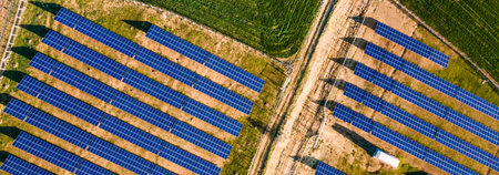 Aerial view of solar power plant with rows of photovoltaic panels for producing clean ecological...