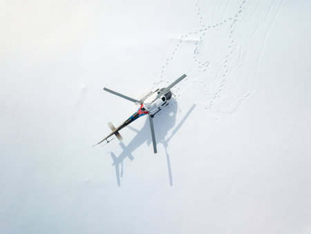 Aerial view of a helicopter flying in the snow in winter.
