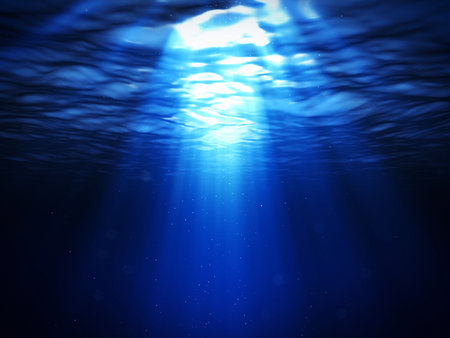 underwater scene with sun rays and dark blue sea water background.の写真素材