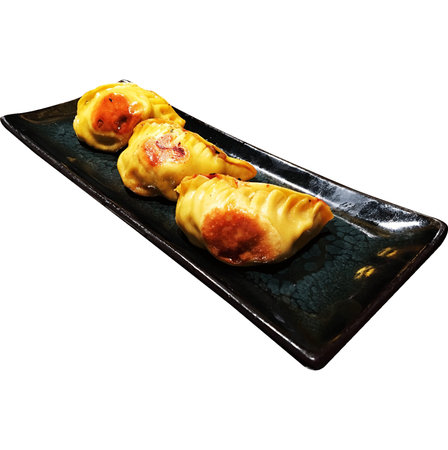 Fried dumplings on a black plate isolated on white backgroundの写真素材