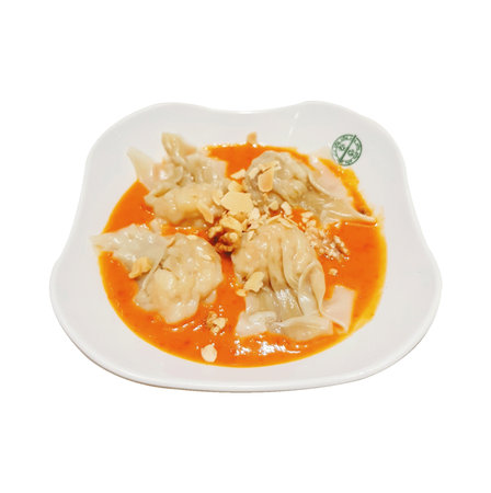 Pork dumplings in red curry sauce isolated on white backgroundの写真素材