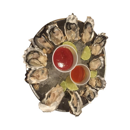 Top view of opened oysters with lime and sauce isolated on white backgroundの写真素材