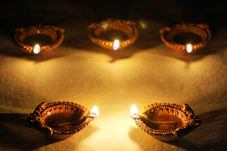 Happy Diwali - Clay Diya lamps lit during Dipavali, Hindu festival of lights celebration.