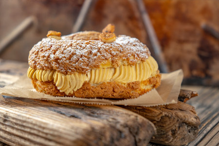 Delicious homemade cake with cream and nuts on a wooden background.