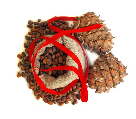 Christmas still life with nuts, cones and red ribbon isolated on a white backgroundの写真素材