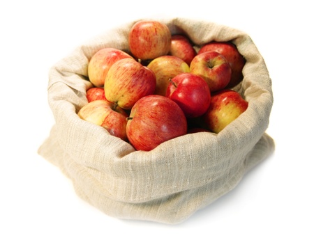 red ripe apples in a flax sack on white backgroundの写真素材