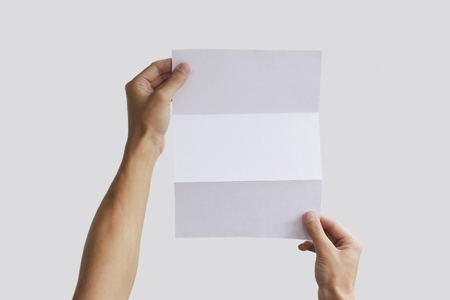 Hand holding blank brochure booklet in the hand. Leaflet presentation. Pamphlet hand man. Man show offset paper. Sheet template. Book in hands. Booklet folding design. Fold paper sheet display read.の写真素材