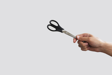 Scissors in hand. Isolated on grey backgroundの写真素材