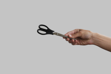 Scissors in hand. Isolated on grey backgroundの写真素材