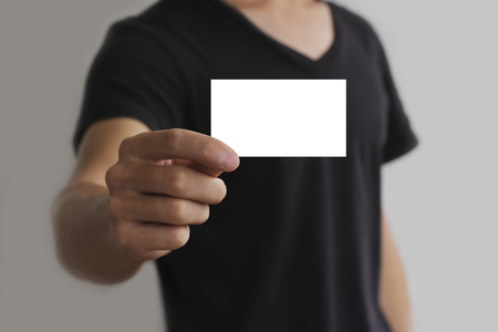 Man offering white card, isolated over grey backgroundの写真素材