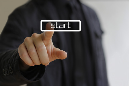Businessman clicks on the start buttonの写真素材