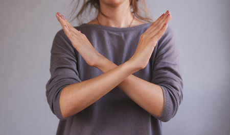 Girl shows no hands. Isolated on gray background.