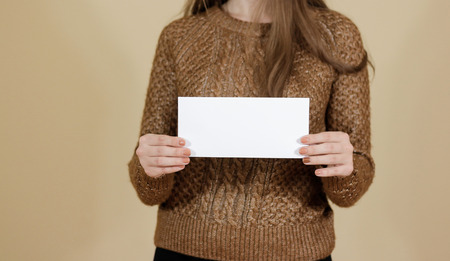 Girl showing blank white flyer brochure booklet. Leaflet presentation. Pamphlet hold hands. Woman show clear offset paper. Sheet template. Booklet design sheet display read first personの写真素材
