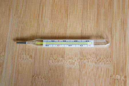 Mercury thermometer on wooden table