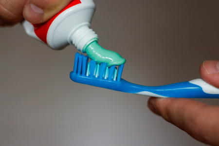 squeezes toothpaste on the brush