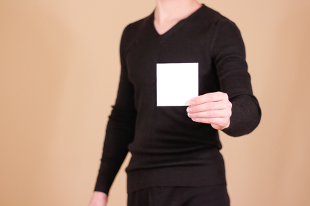Man showing blank white square flyer brochure booklet. Leaflet presentation. Pamphlet hold hands. Man show clear offset paper. Sheet template. Booklet design sheet display read first personの写真素材