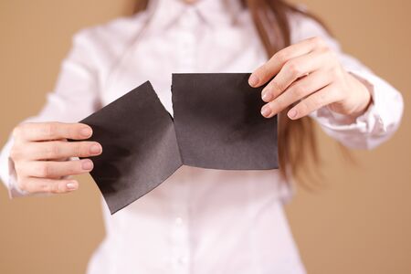 Girl tearing a piece of paper in half blank white flyer brochure booklet. Leaflet presentation. Pamphlet hold hands. Woman show clear offset paper. Sheet template. Booklet design sheet display read first personの写真素材