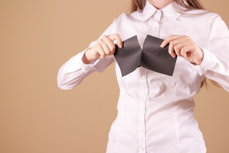 Girl tearing a piece of paper in half blank white flyer brochure booklet. Leaflet presentation. Pamphlet hold hands. Woman show clear offset paper. Sheet template. Booklet design sheet display read first personの写真素材
