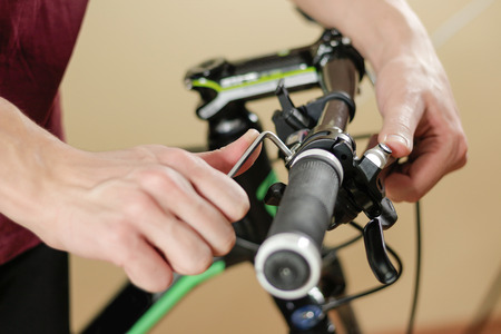 Bike repair. Bicycle fixing. Hex wrench works. Man configures the bike.の写真素材