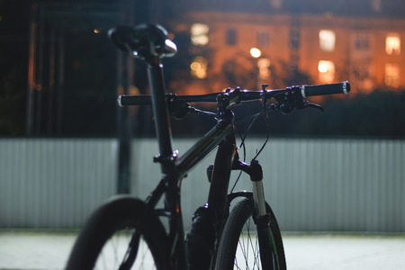 Bike night on the street. Town in the background and glowing windows.の写真素材