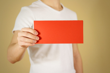 Man showing blank red flyer brochure booklet. Leaflet presentation. Pamphlet hold hands. Man show...