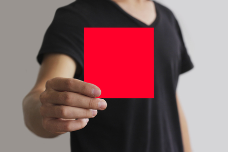 Man showing blank red square flyer brochure booklet. Leaflet presentation. Pamphlet hold hands. Man show clear offset paper. Sheet template. Booklet design sheet display read first personの写真素材