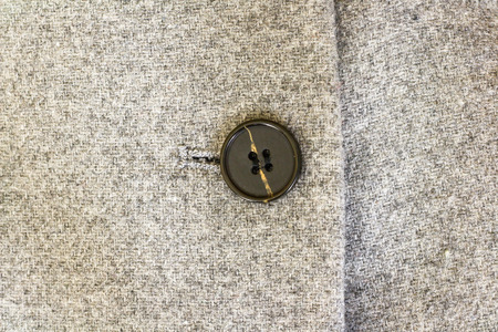 Grey tweed texture, black buttons on a grey wool coat.