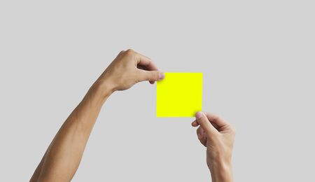 Two hands holding square paper in the hand. Leaflet presentation. Pamphlet hand man. Man show offset paper. Sheet template. Book in hands. Booklet folding design. Fold paper sheet display read.の写真素材