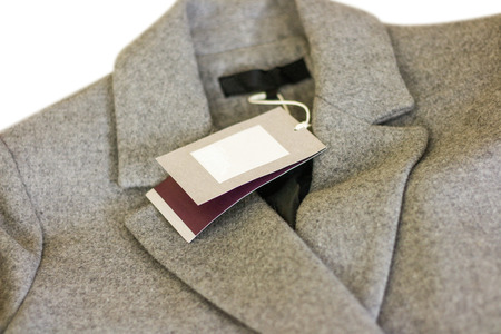 Close up price tag of grey wool coat. Clothes, wear and fashion concept