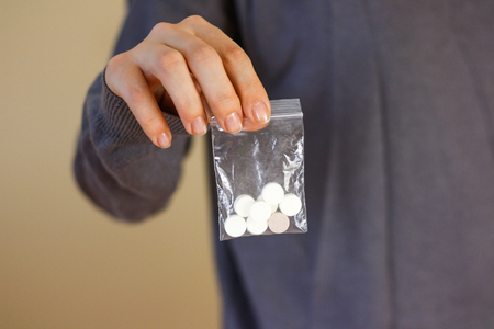Treatment tablets. Close-up of a white pack pills in woman's fingers.の写真素材