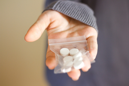 Treatment tablets. Close-up of a white pack pills in woman's fingers.の写真素材