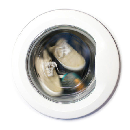 Many pairs of dirty sneakers in the washing machineの写真素材