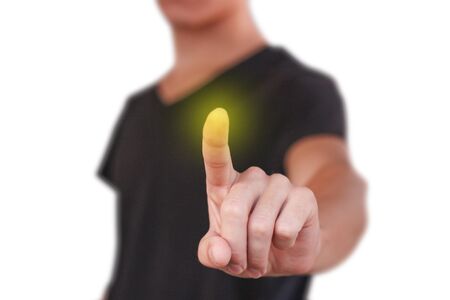 A young guy in a black t-shirt pressing on the screen. Isolated on white background.の写真素材