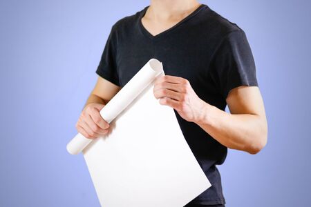 Guy holds in his hands twisted up in paper. Opens the package of paper. Shows a blank sheet rolled...