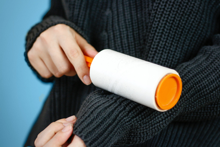 Girl cleans clothes sticky roller. Close up. Isolated.の写真素材